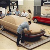 Studio photos showing the fiberglass model in the background, as development progresses productionizing the design.