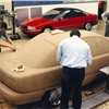 Studio photos showing the fiberglass model in the background, as development progresses productionizing the design.