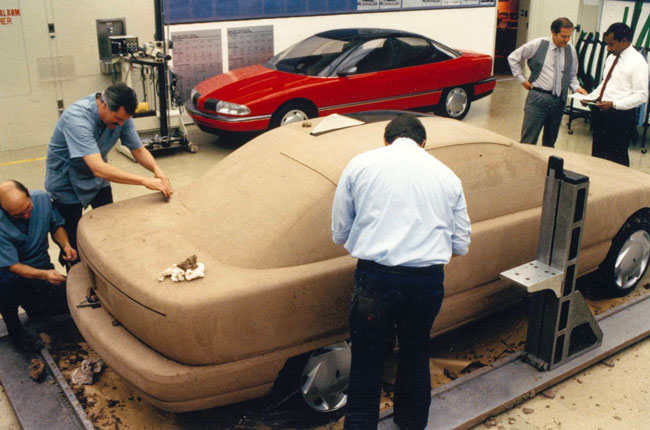Studio photos showing the fiberglass model in the background, as development progresses productionizing the design.
